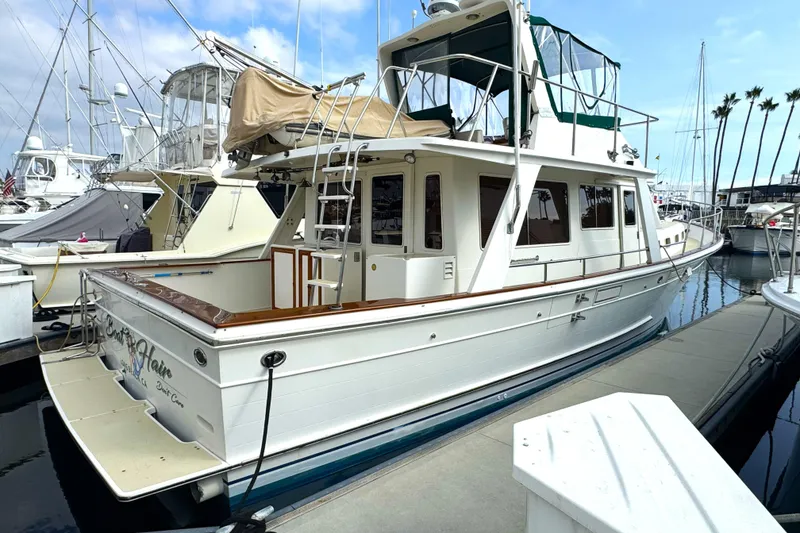Slide: The Image of 1988 Offshore Yachts 48 Sedan docked at marina, featuring classic design and spacious deck. - 1