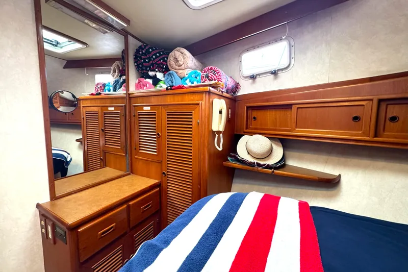Slide: The Image of Cozy cabin interior of 1988 Offshore Yachts 48 Sedan with wooden cabinetry and nautical decor. - 11