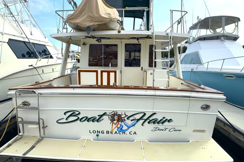 Slide: The Image of 1988 Offshore Yachts 48 Sedan docked, featuring "Boat Hair Don't Care" text, Long Beach, CA. - 2