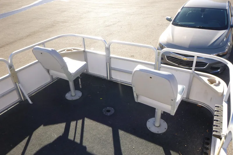 Slide: The Image of 2003 Smoker Craft 816 Infinity Fish boat interior with two seats, parked near a car. - 8