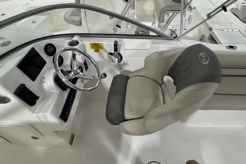 Slide: The Image of 2026 Key West 203 DFS boat interior with steering wheel and cushioned seat. - 10