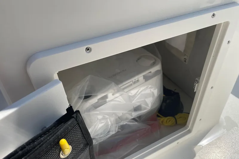 Slide: The Image of Storage compartment on a 2026 Key West 203 DFS boat, containing various items. - 10