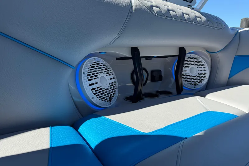 Slide: The Image of 2025 Centurion Ri230 boat interior with blue and white seating, featuring built-in speakers. - 10