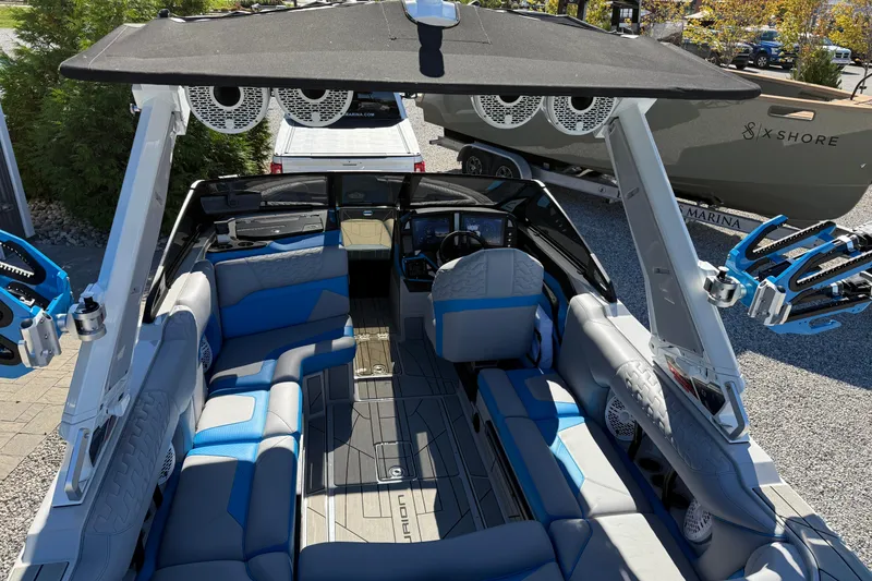 Slide: The Image of 2025 Centurion Ri230 boat interior with blue and gray seating, advanced audio system, and sleek design. - 6