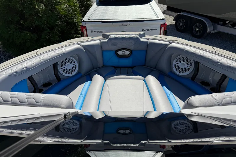 Slide: The Image of 2025 Centurion Ri230 boat interior with blue and gray seating, featuring built-in speakers. - 8