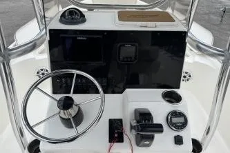 Slide: The Image of 2023 Bulls Bay 2400 boat console with steering wheel and navigation controls. - 8