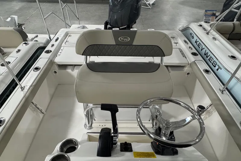 Slide: The Image of 2026 Key West 210 Bay Reef boat interior with steering wheel and seating. - 10