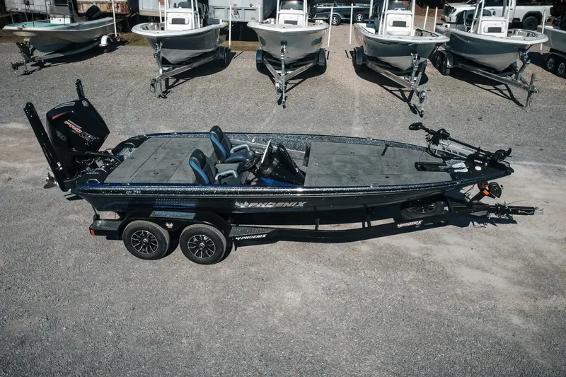 Slide: The Image of 2026 Phoenix 721 ZXL bass boat on trailer, surrounded by other boats in a lot. - 2