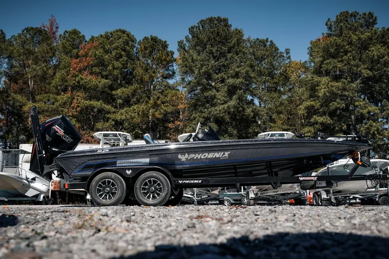 Slide: The Image of 2026 Phoenix 721 ZXL boat on trailer, surrounded by trees and other boats. - 45