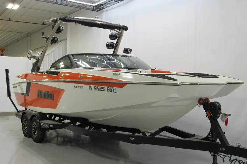 Slide: The Image of 2021 Malibu Wakesetter 24 MXZ boat on trailer in indoor showroom. - 1