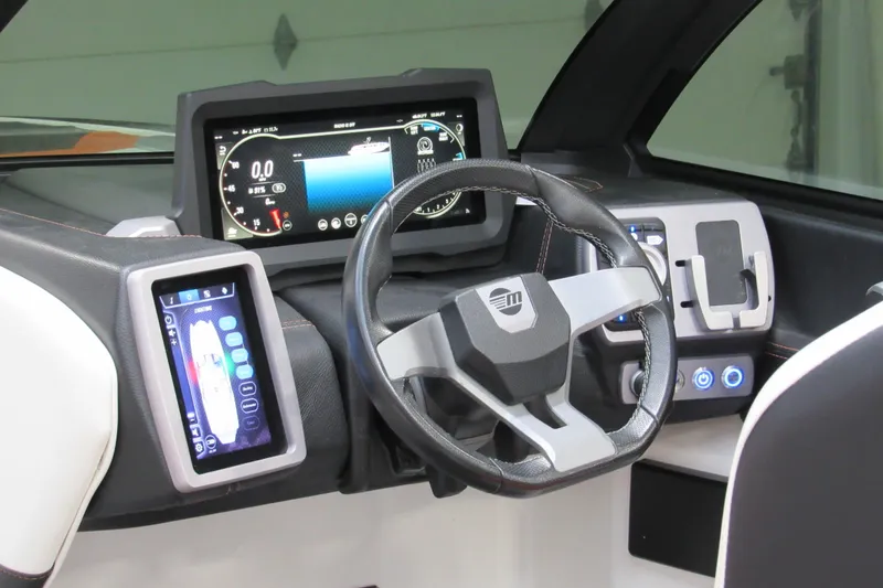 Slide: The Image of 2021 Malibu Wakesetter 24 MXZ dashboard with advanced digital displays and steering wheel. - 12