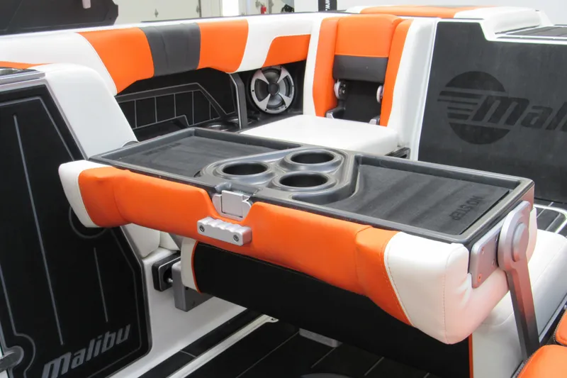 Slide: The Image of 2021 Malibu Wakesetter 24 MXZ interior with orange and white seating, featuring a foldable table. - 20