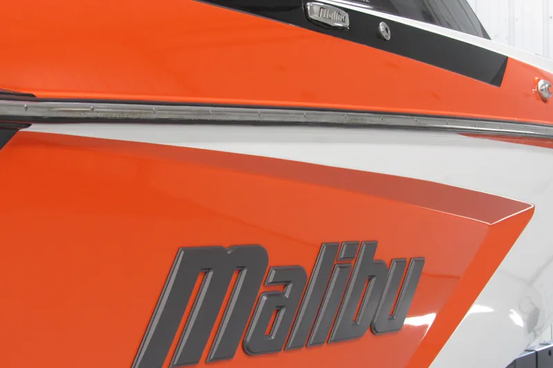 Slide: The Image of 2021 Malibu Wakesetter 24 MXZ boat, orange and white exterior, close-up view. - 3