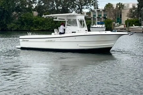 The Image of 2002 Shamrock 270 Open boat on calm water, surrounded by greenery and buildings. - 1