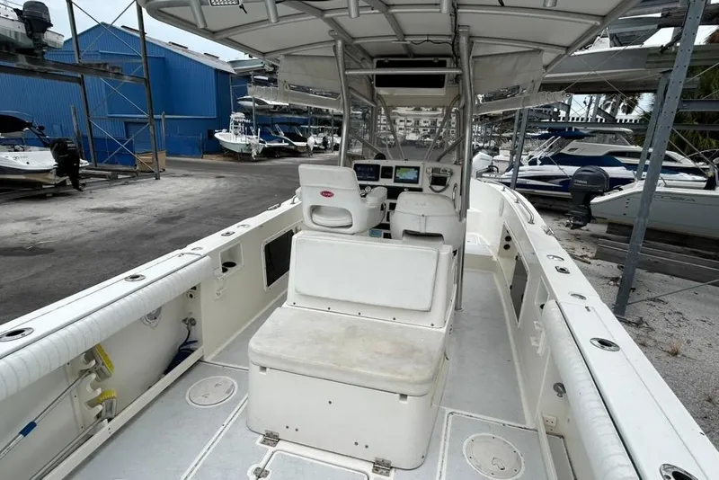 Slide: The Image of 2002 Shamrock 270 Open boat interior, featuring seating and control panel in a marina setting. - 14