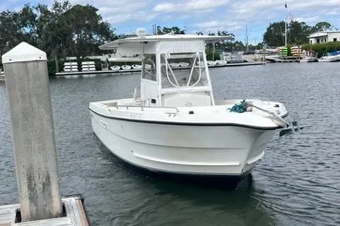 Slide: The Image of 2002 Shamrock 270 Open boat docked in a marina, under a partly cloudy sky. - 3