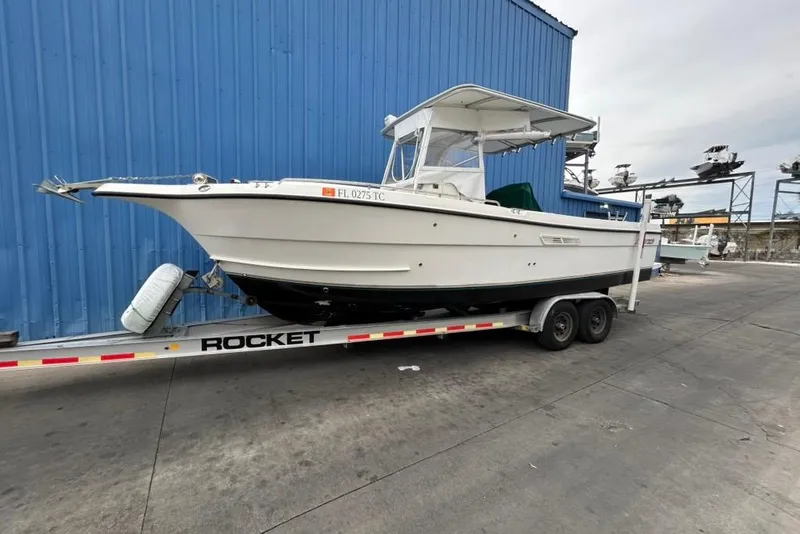 Slide: The Image of 2002 Shamrock 270 Open boat on trailer, parked by blue building. - 4