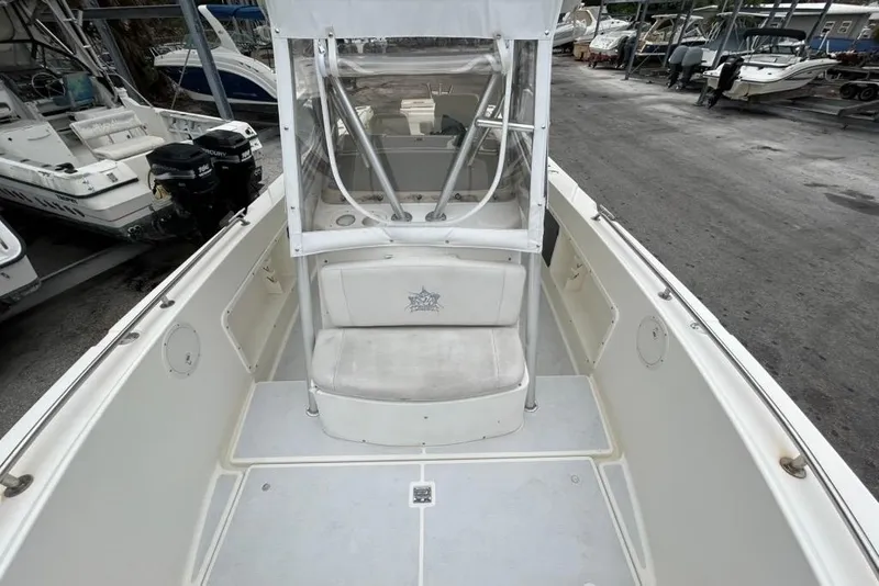 Slide: The Image of 2002 Shamrock 270 Open boat interior, featuring seating and console, docked among other boats. - 8