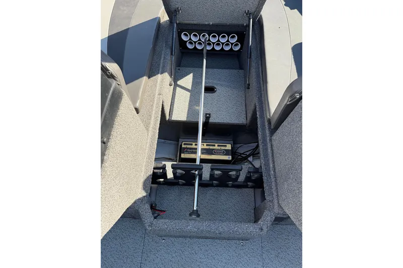 Slide: The Image of 2019 Lund 2025 Impact XS boat interior with rod storage and battery compartment. - 16