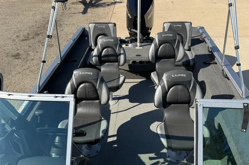 Slide: The Image of 2019 Lund 2025 Impact XS boat interior with six black seats and windshield. - 18