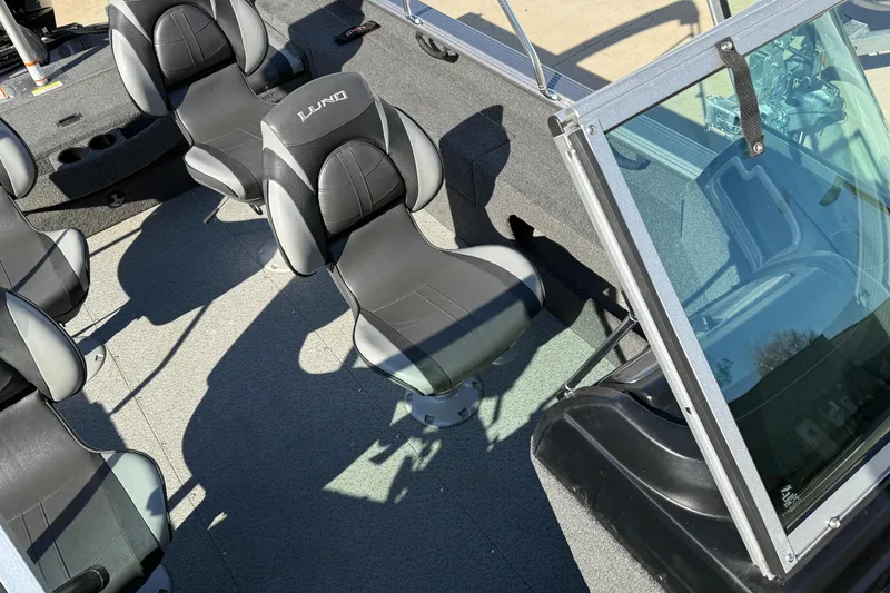 Slide: The Image of 2019 Lund 2025 Impact XS boat interior with black and gray seating. - 20