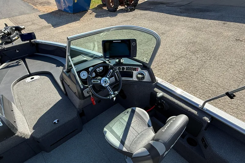 Slide: The Image of 2019 Lund 2025 Impact XS boat interior with steering console and seating. - 21