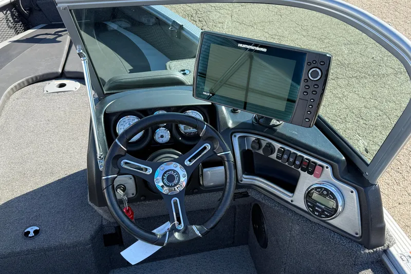 Slide: The Image of 2019 Lund 2025 Impact XS boat dashboard with steering wheel and Humminbird fish finder. - 22