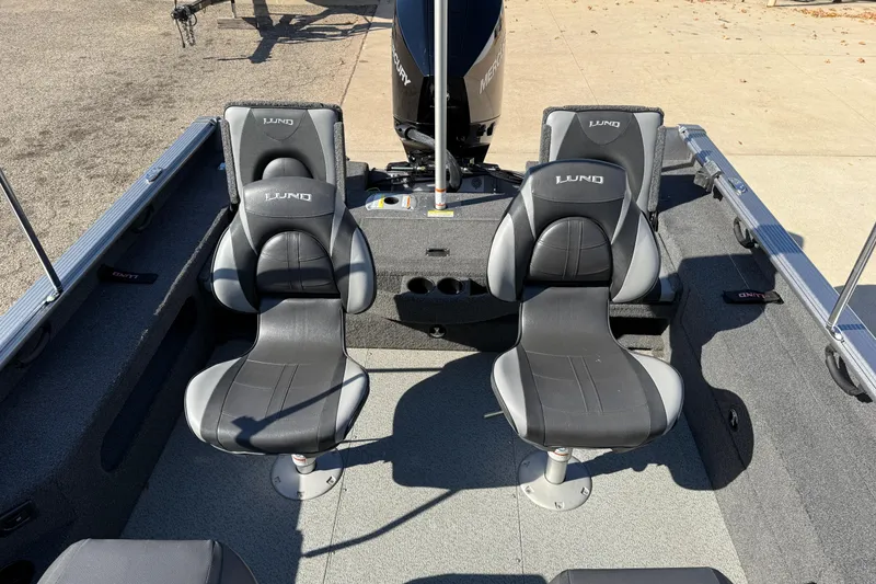 Slide: The Image of 2019 Lund 2025 Impact XS boat interior with two black and gray seats. - 28