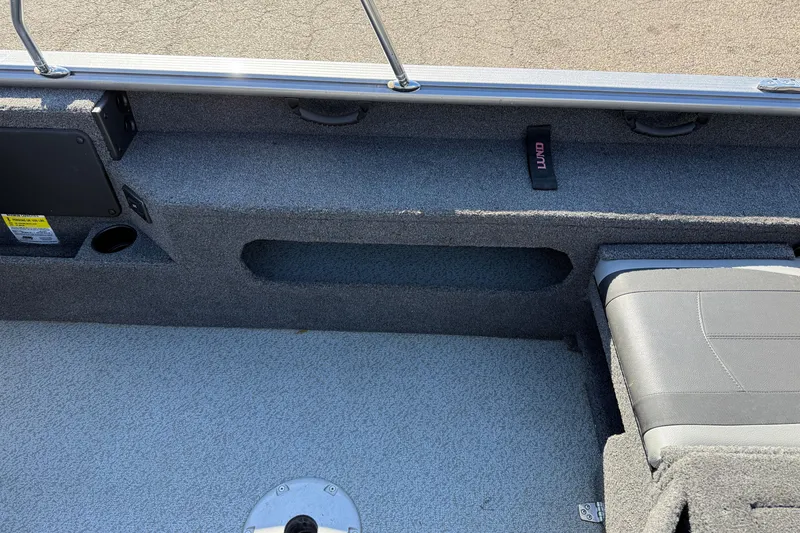 Slide: The Image of 2019 Lund 2025 Impact XS boat interior with gray carpet and seating. - 29