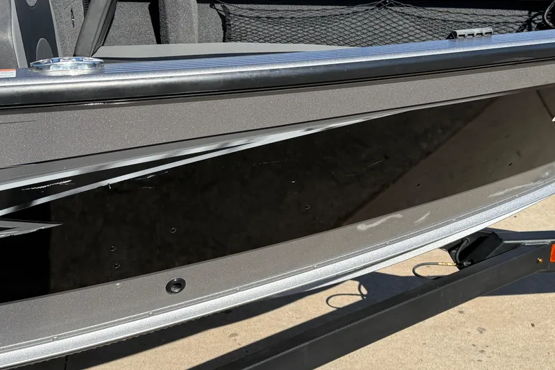 Slide: The Image of 2019 Lund 2025 Impact XS boat side view with sleek black and gray design. - 37