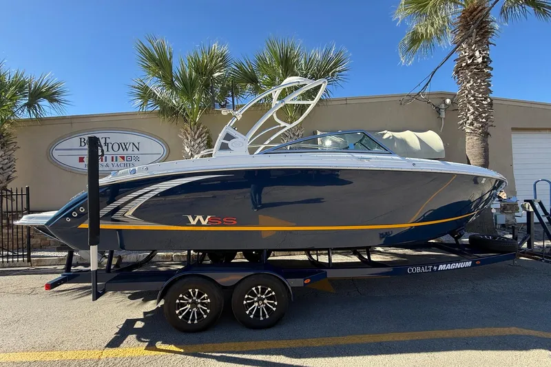 The Image of 2018 Cobalt R7 Surf boat on trailer, parked near palm trees. - 1