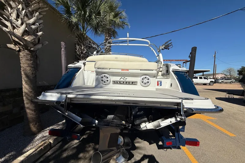 Slide: The Image of 2018 Cobalt R7 Surf boat parked, rear view with palm trees and clear sky. - 5