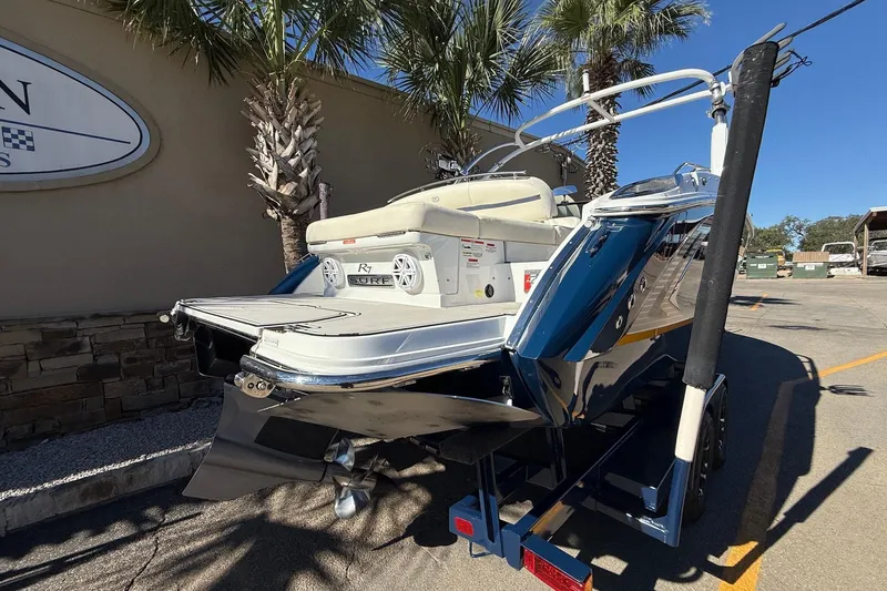 Slide: The Image of 2018 Cobalt R7 Surf boat on trailer, parked near palm trees. - 6