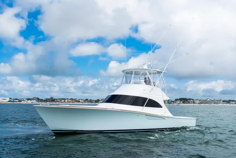 Slide: The Image of 2026 Viking 46 Billfish yacht cruising on open water under a cloudy sky. - 2