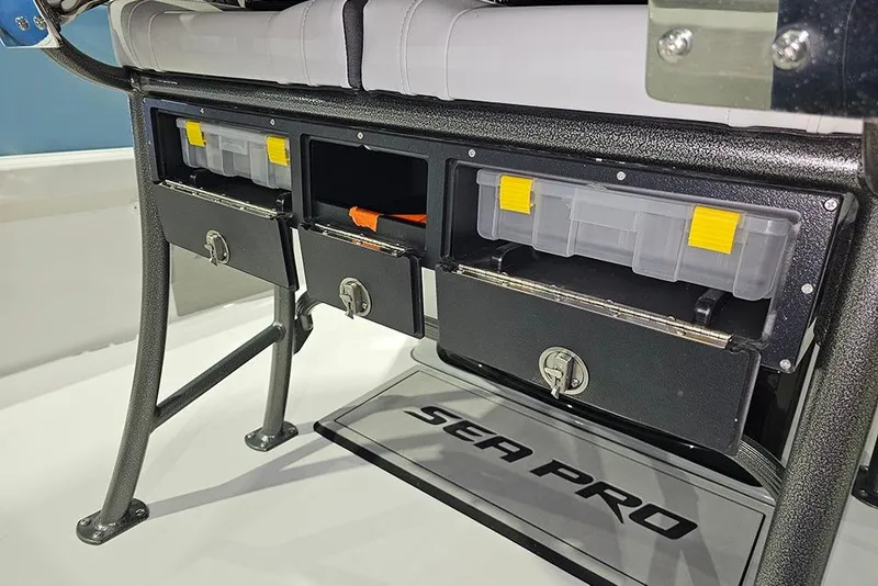 Slide: The Image of 2026 Sea Pro 250 Bay boat storage compartments with tackle boxes and secure locks. - 12