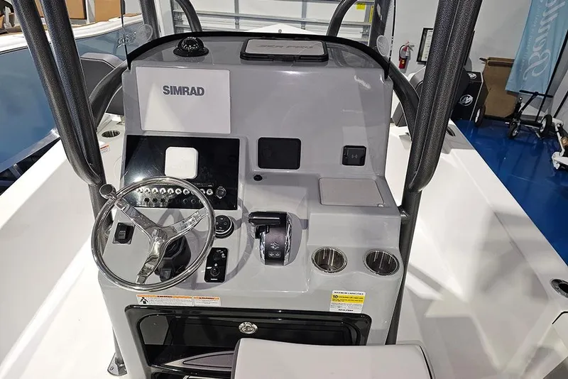 Slide: The Image of 2026 Sea Pro 250 Bay boat console with steering wheel and Simrad display. - 14