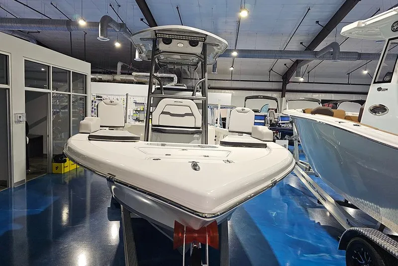 Slide: The Image of 2026 Sea Pro 250 Bay boat displayed in a showroom, showcasing sleek design and modern features. - 2