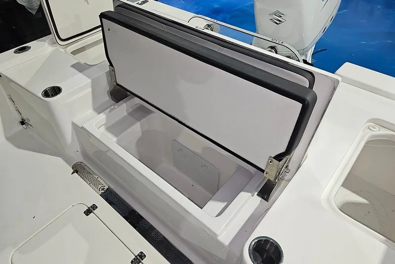 Slide: The Image of 2026 Sea Pro 250 Bay boat with open storage compartment and cup holders. - 8