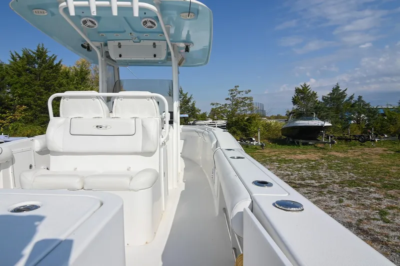 Slide: The Image of 2015 Sea Hunt Gamefish 30 boat with white seating and canopy, parked outdoors. - 10
