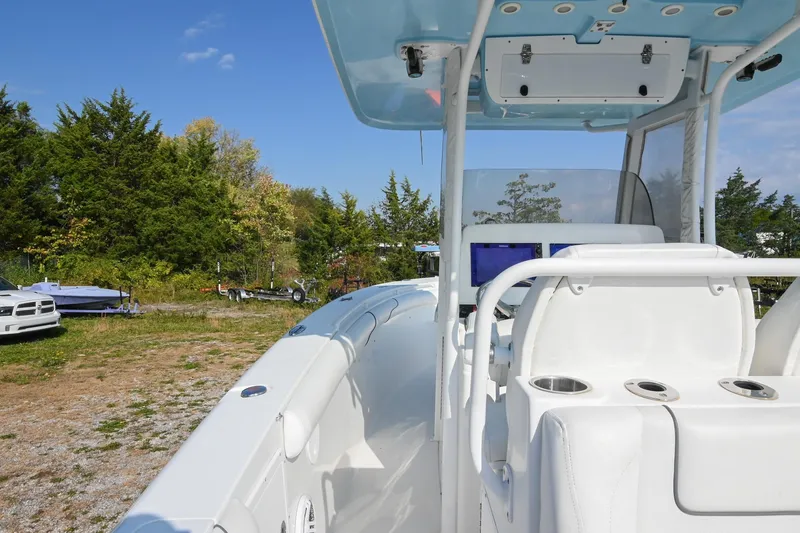 Slide: The Image of 2015 Sea Hunt Gamefish 30 boat interior with console and seating, surrounded by trees. - 17
