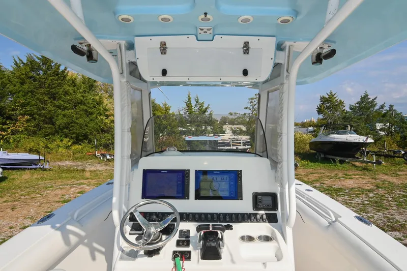 Slide: The Image of 2015 Sea Hunt Gamefish 30 boat cockpit with navigation screens and steering wheel. - 18