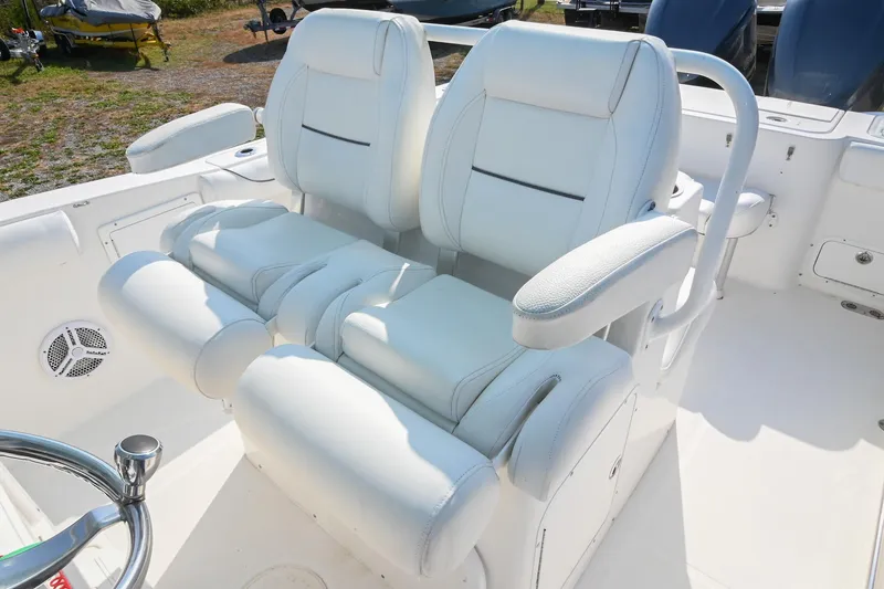 Slide: The Image of 2015 Sea Hunt Gamefish 30 boat with white cushioned seating and steering wheel. - 22