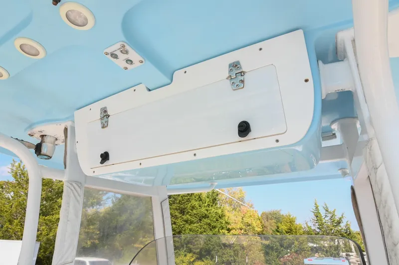 Slide: The Image of 2015 Sea Hunt Gamefish 30 boat interior, featuring a blue and white overhead compartment. - 23