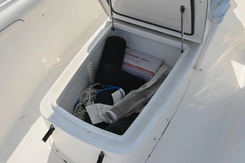Slide: The Image of Storage compartment on 2015 Sea Hunt Gamefish 30 boat with life jacket and ropes. - 33