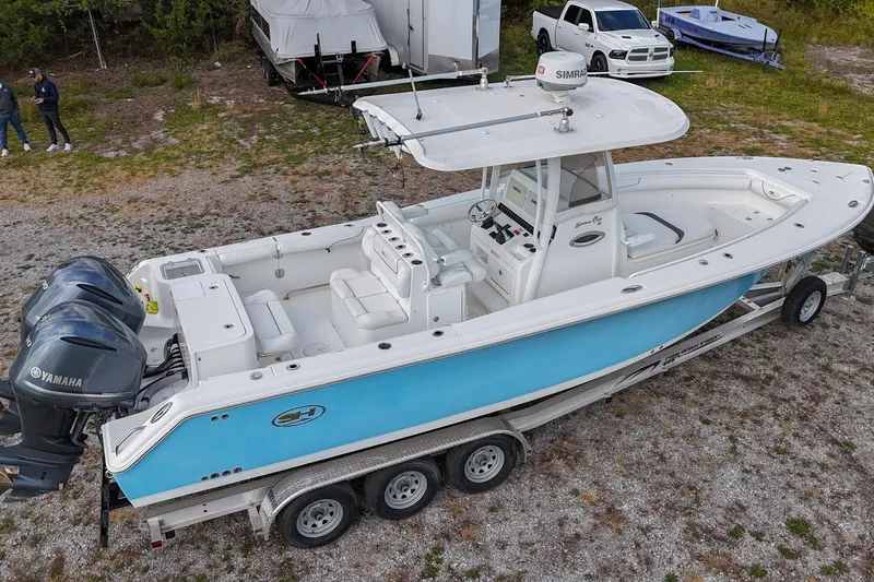Slide: The Image of 2015 Sea Hunt Gamefish 30 boat on trailer with dual Yamaha engines, parked outdoors. - 38