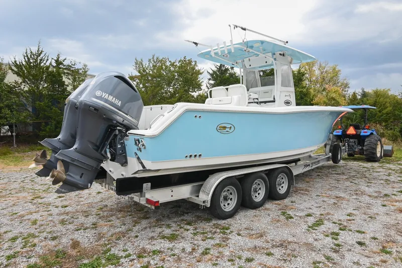 Slide: The Image of 2015 Sea Hunt Gamefish 30 boat on trailer with Yamaha engines, parked outdoors. - 5