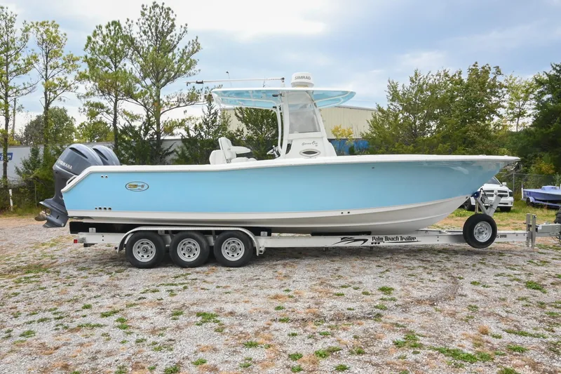 Slide: The Image of 2015 Sea Hunt Gamefish 30 boat on trailer, light blue hull, parked outdoors. - 6