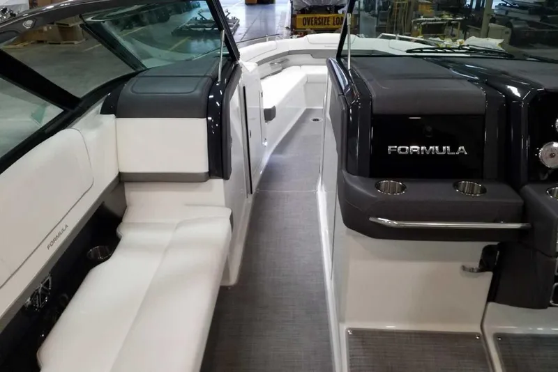 Slide: The Image of 2019 Formula 330 Crossover Bowrider storage compartment with cup holders and cleaning supplies. - 26