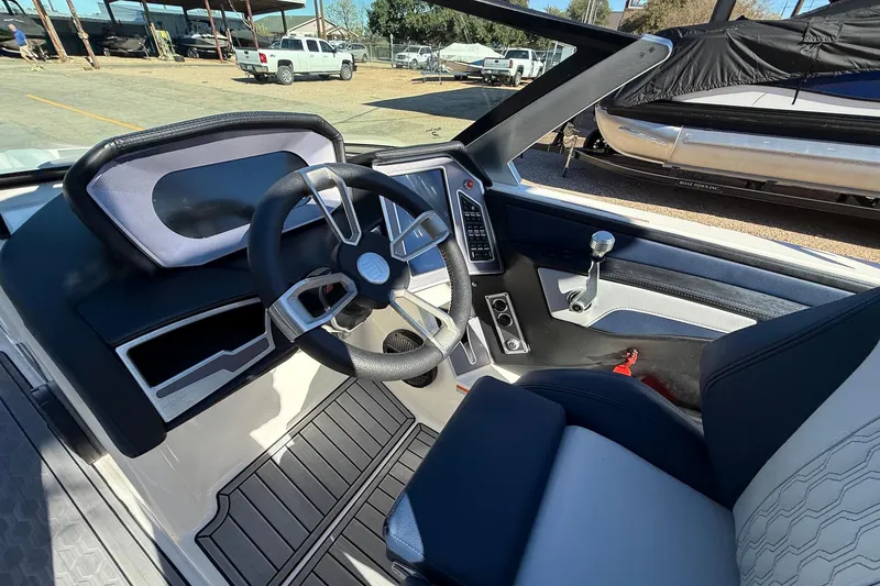 Slide: The Image of Interior of a 2023 MasterCraft XT23 boat, featuring a sleek steering wheel and modern dashboard. - 10