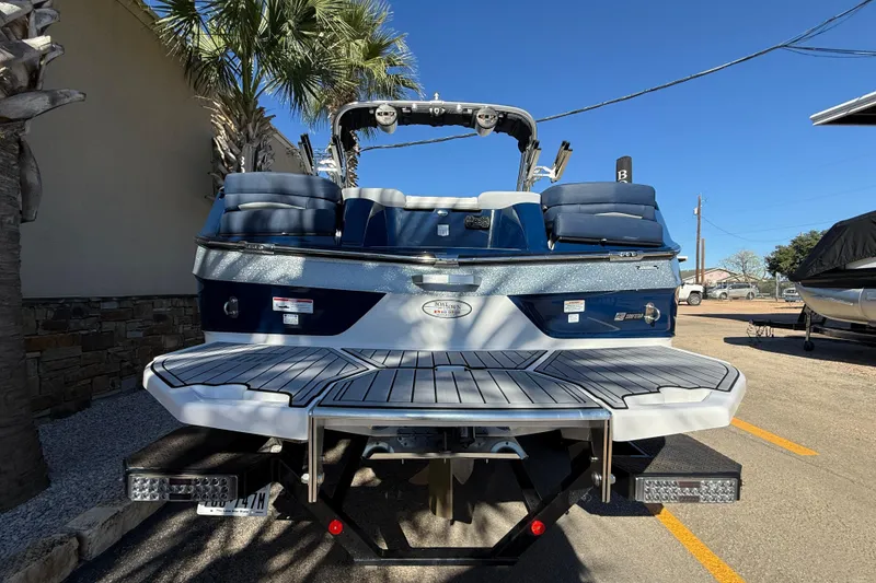 Slide: The Image of 2023 MasterCraft XT23 boat, rear view, showcasing sleek design and spacious deck. - 5